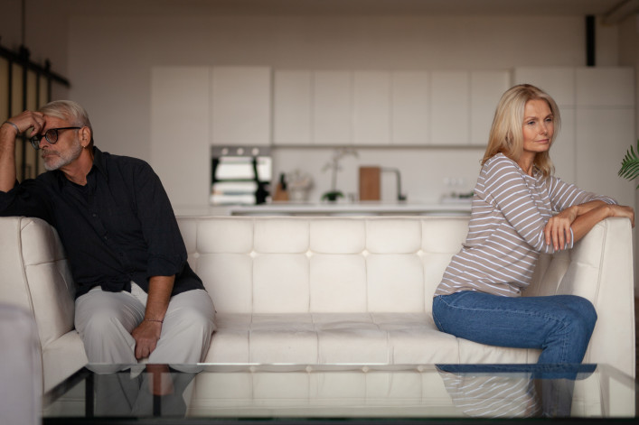 Quarrel in a mature family. Senior husband and wife are sitting on opposite sides of the sofa in the interior of the apartment. Relationship difficulties stock photo Quarrel in a mature family. Senior husband and wife are sitting on opposite sides of the sofa in the interior of the apartment. Relationship difficulties stock photo