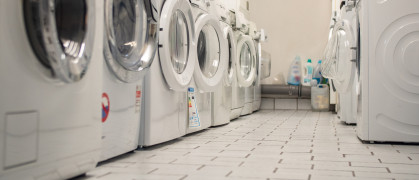 Laundry room of an apartment house in the basement with some washers in a row stock photo
